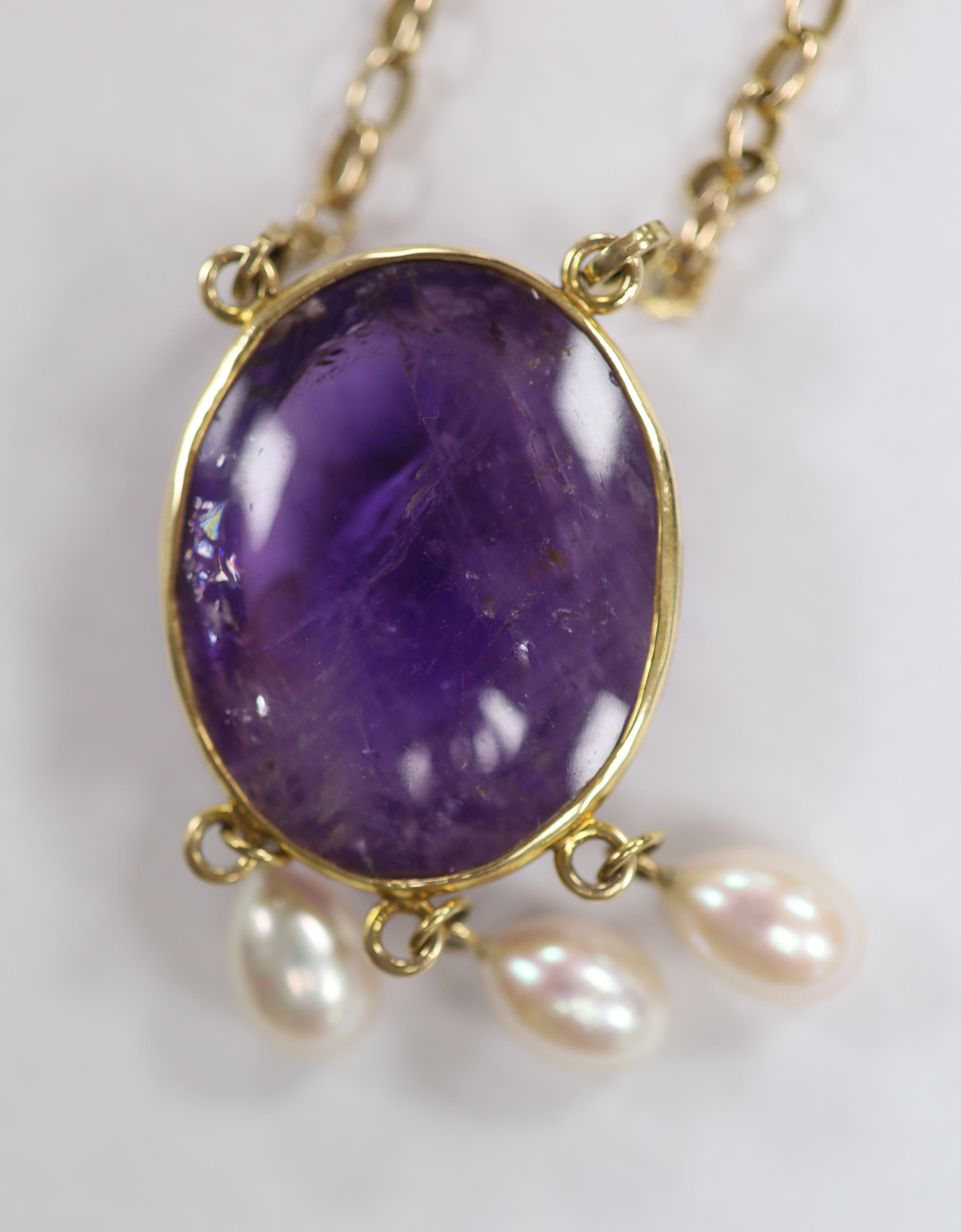 A modern yellow metal mounted, oval amethyst pebble and three stone cultured pearl set drop pendant, 66mm, on a 9ct gold chain